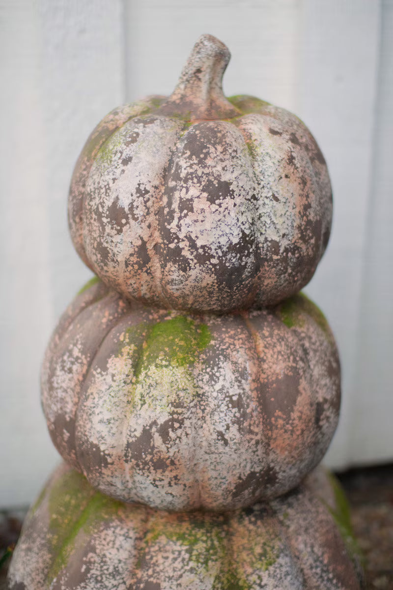 three stacked faux concrete pumpkins