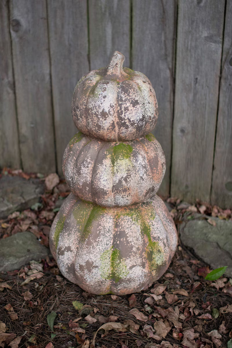 three stacked faux concrete pumpkins