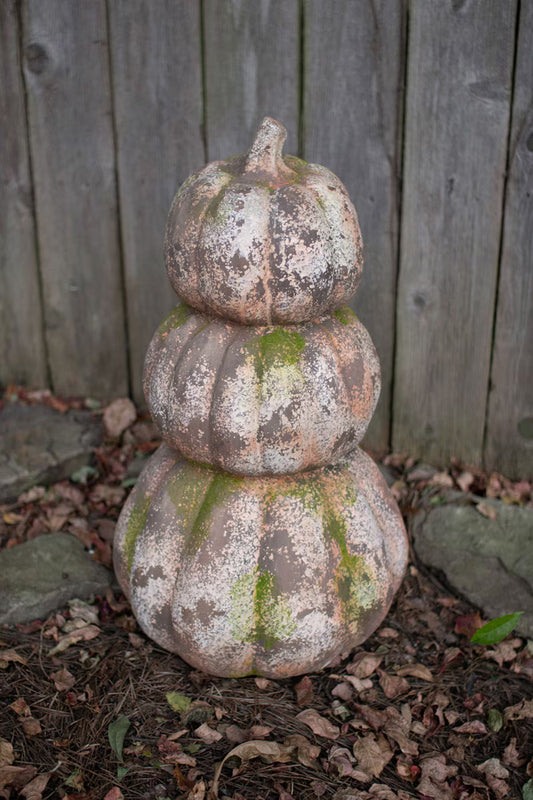 three stacked faux concrete pumpkins